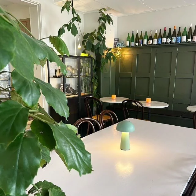 Interiör hos Ateljén med grön panel och bistrobord